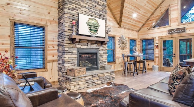 living room with wooden ceiling, wood walls, and high vaulted ceiling