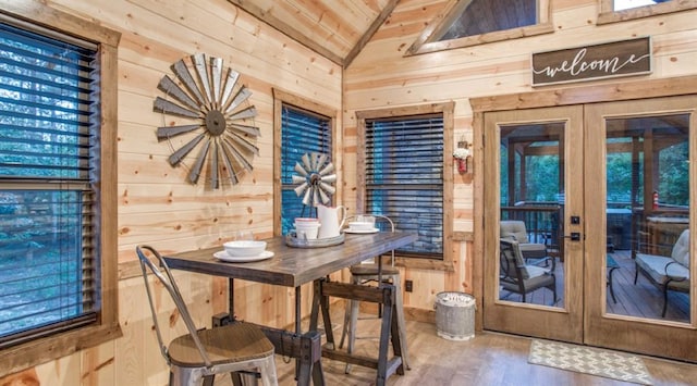 dining space with wooden walls, french doors, wooden ceiling, and vaulted ceiling