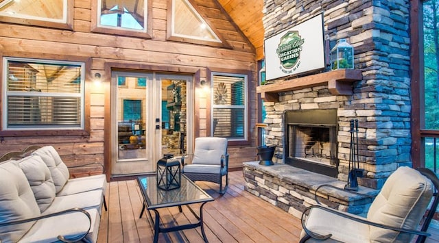 wooden terrace featuring an outdoor stone fireplace