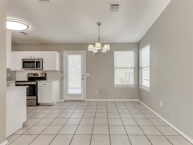 14813 Moon Daisy Dr, Edmond, OK 73013 - kitchen featuring light countertops, visible vents, a wealth of natural light, and stainless steel appliances