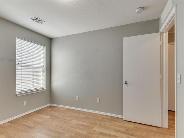 14813 Moon Daisy Dr, Edmond, OK 73013 - unfurnished room with visible vents, light wood finished floors, and baseboards
