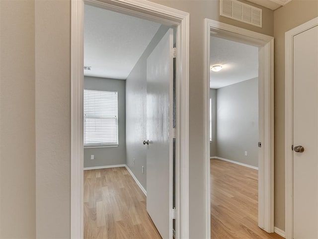 14813 Moon Daisy Dr, Edmond, OK 73013 - corridor with baseboards, light wood-style floors, and visible vents