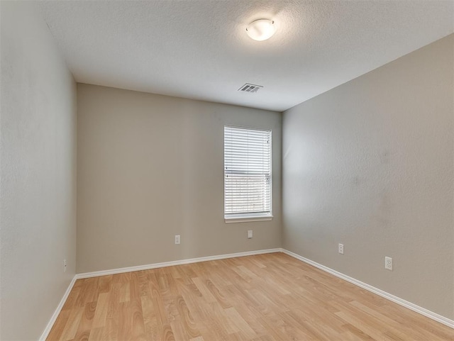 14813 Moon Daisy Dr, Edmond, OK 73013 - unfurnished room with visible vents, light wood-style flooring, baseboards, and a textured ceiling
