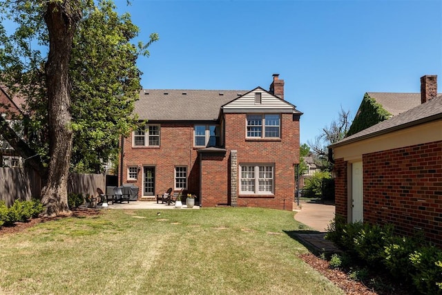 812 NW 38th St, Oklahoma City, OK 73118 - back of house featuring a chimney, a lawn, fence, a patio, and brick siding
