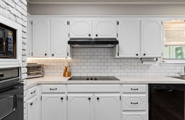 kitchen featuring under cabinet range hood, backsplash, crown molding, black appliances, and white cabinetry