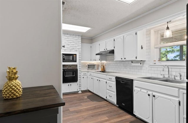 kitchen featuring tasteful backsplash, a sink, a textured ceiling, black appliances, and under cabinet range hood