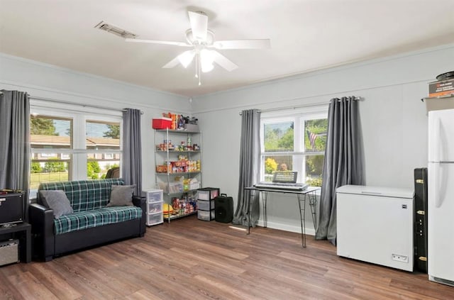 sitting room featuring wood finished floors, visible vents, a wealth of natural light, and ceiling fan