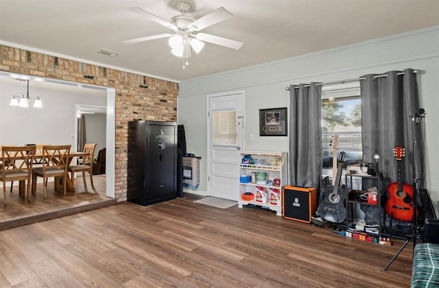 recreation room with crown molding, a ceiling fan, wood finished floors, and visible vents