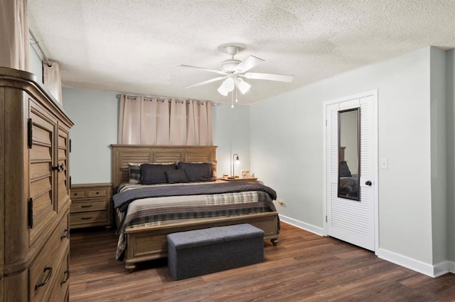 bedroom with baseboards, a textured ceiling, and dark wood-type flooring