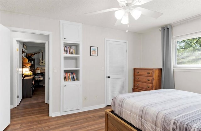 bedroom with baseboards, a ceiling fan, wood finished floors, and a textured ceiling