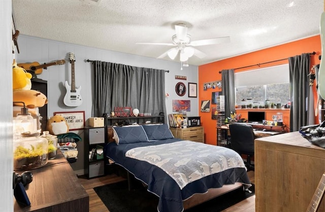 bedroom with wood finished floors, a textured ceiling, and a ceiling fan