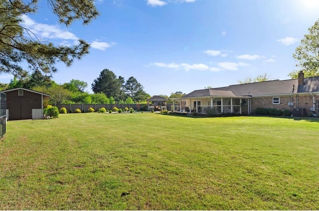 view of yard featuring fence, a storage shed, central air condition unit, an outbuilding, and a gazebo