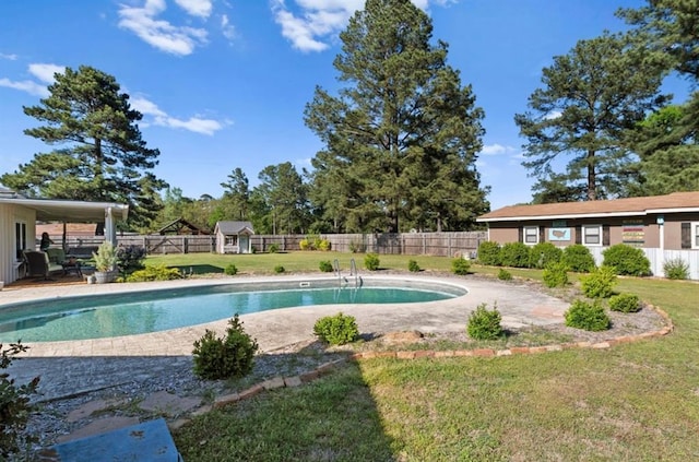 view of swimming pool featuring a fenced in pool, an outbuilding, a fenced backyard, a yard, and a patio