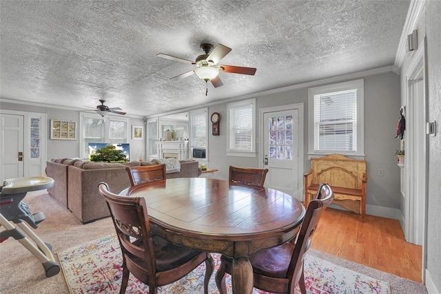 121 S Randlett St, Hobart, OK 73651 - dining space with ceiling fan, a fireplace, light wood-style flooring, a textured ceiling, and ornamental molding