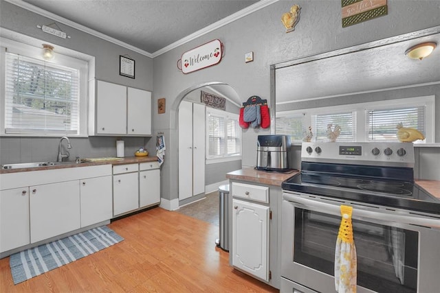 121 S Randlett St, Hobart, OK 73651 - kitchen featuring white cabinets, a sink, light wood-style floors, a textured ceiling, and stainless steel electric range