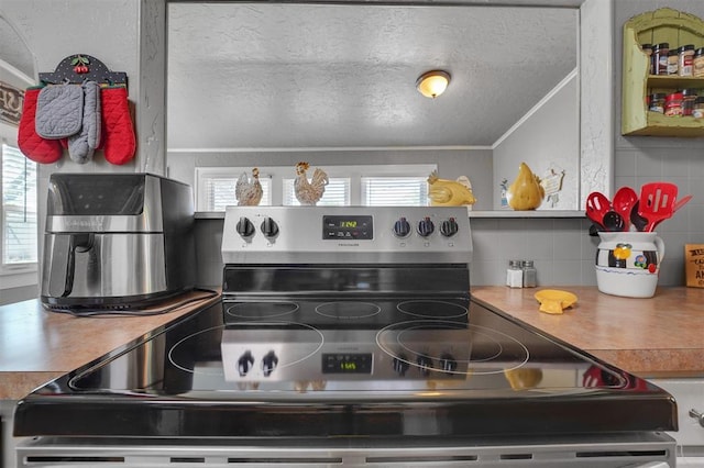 121 S Randlett St, Hobart, OK 73651 - kitchen featuring tasteful backsplash, open shelves, stainless steel range with electric stovetop, a textured ceiling, and crown molding