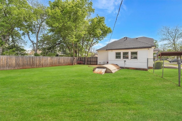 121 S Randlett St, Hobart, OK 73651 - back of property with a carport, a fenced backyard, a shingled roof, and a lawn