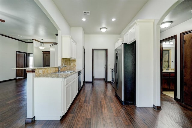 73 Bonaire Dr, Edmond, OK 73013 - kitchen with freestanding refrigerator, a sink, a peninsula, and dark wood-style floors