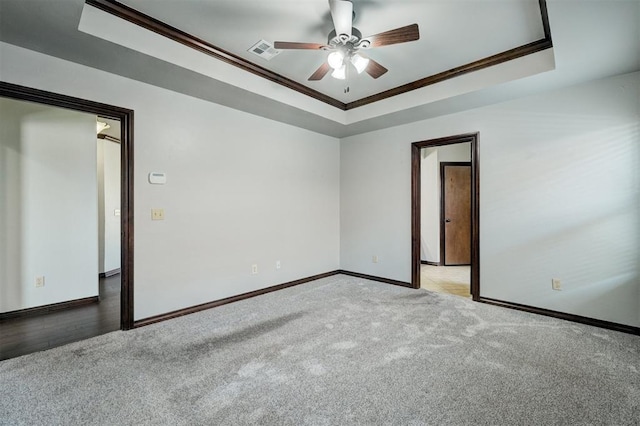 73 Bonaire Dr, Edmond, OK 73013 - unfurnished room featuring crown molding, baseboards, ceiling fan, a tray ceiling, and carpet flooring