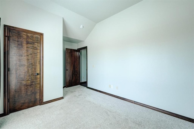 73 Bonaire Dr, Edmond, OK 73013 - unfurnished bedroom featuring carpet floors, baseboards, and lofted ceiling