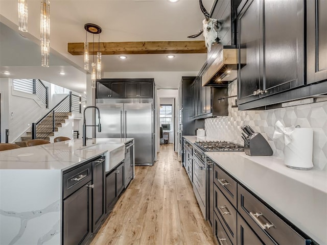1330 Acclivis Ct, Newcastle, OK 73065 - kitchen with beamed ceiling, light wood-style flooring, hanging light fixtures, high quality appliances, and decorative backsplash