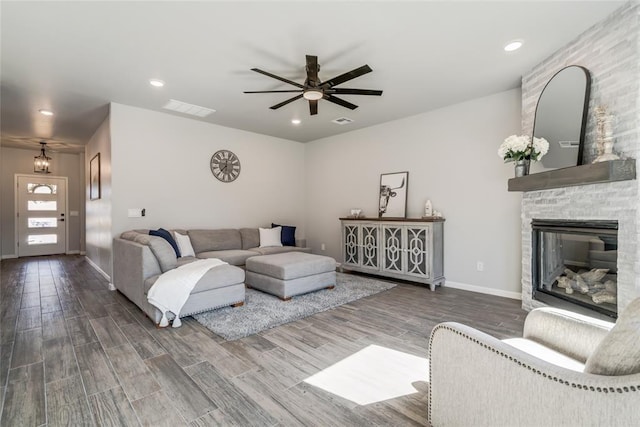 living room with wood finished floors, ceiling fan, baseboards, and visible vents