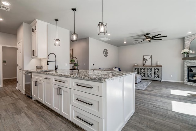 kitchen featuring open floor plan, dark wood-type flooring, visible vents, ceiling fan, and a sink
