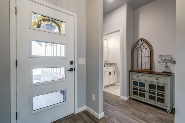 foyer entrance featuring baseboards and wood finished floors