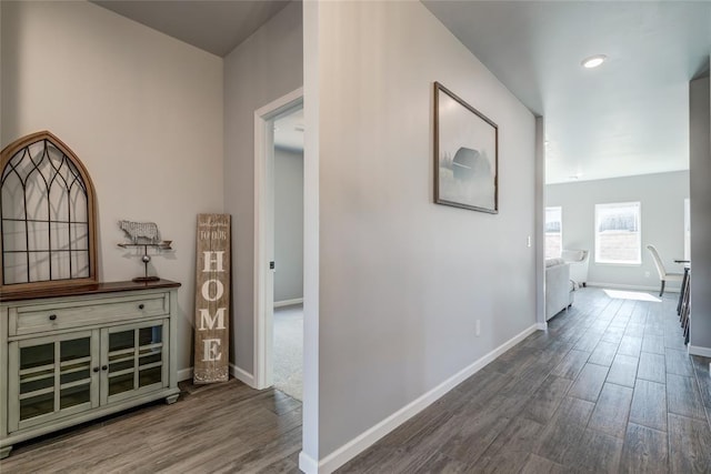 corridor with baseboards and wood finished floors