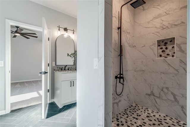 full bath with vanity, a marble finish shower, and ceiling fan