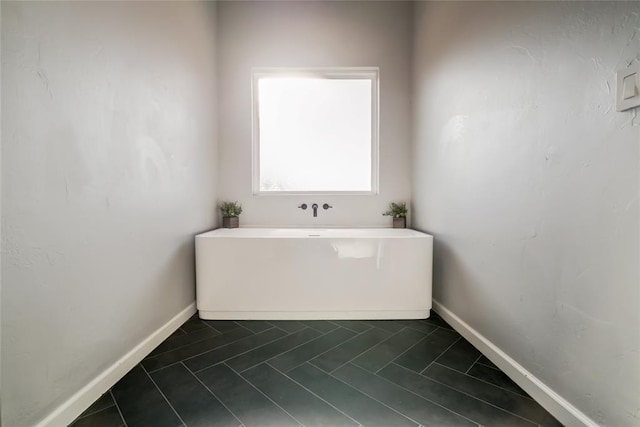 full bath with tile patterned flooring, baseboards, and a soaking tub