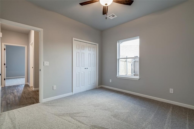 unfurnished bedroom featuring visible vents, baseboards, a closet, a ceiling fan, and carpet flooring