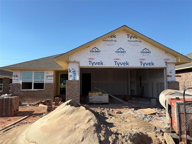 2321 SE 89th Ter, Oklahoma City, OK 73160 - property in mid-construction featuring an attached garage, brick siding, roof with shingles, and driveway