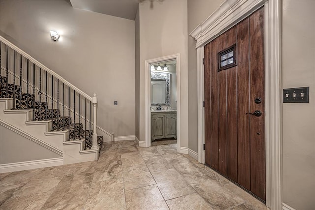 entryway with a towering ceiling, baseboards, and stairway