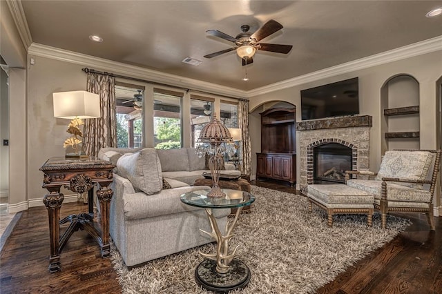 living area featuring baseboards, ornamental molding, visible vents, ceiling fan, and wood finished floors