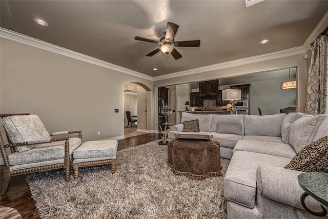 living room featuring baseboards, recessed lighting, a ceiling fan, arched walkways, and wood finished floors