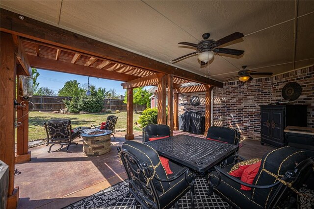 view of patio featuring outdoor dining space, a fire pit, a fenced backyard, and a ceiling fan