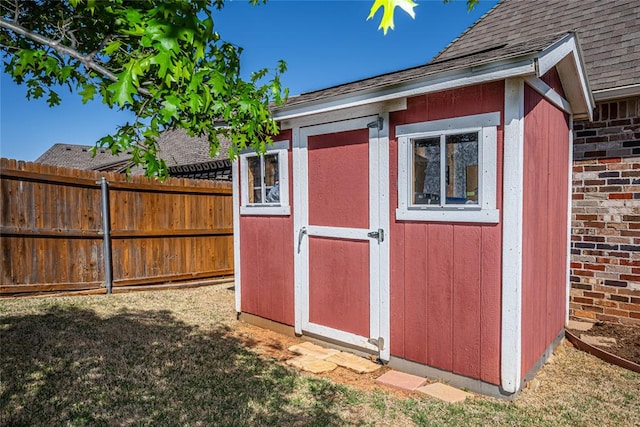 view of shed featuring fence