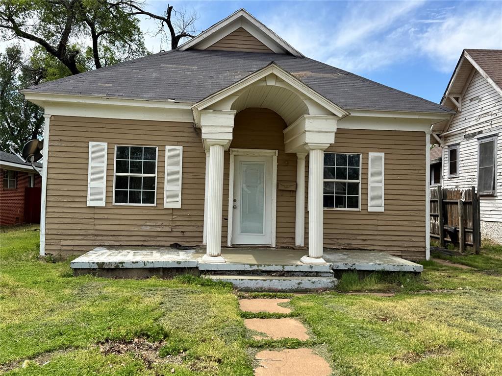 bungalow with a porch and a front lawn
