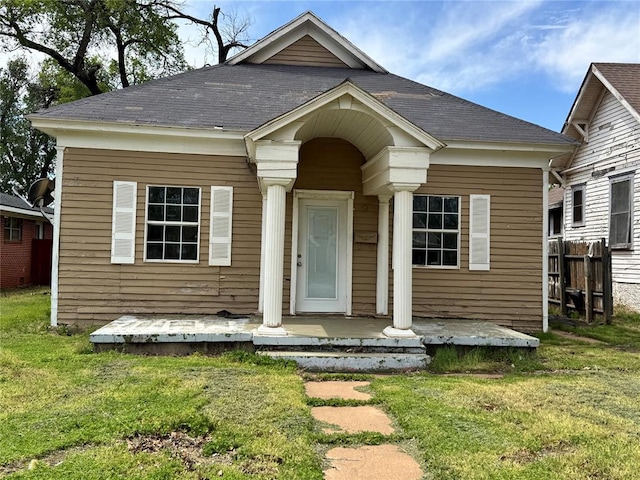bungalow with a porch and a front lawn
