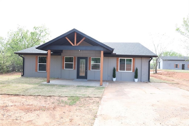 2187 County Road 1268, Blanchard, OK 73010 - ranch-style house with brick siding, a front yard, a shingled roof, and covered porch