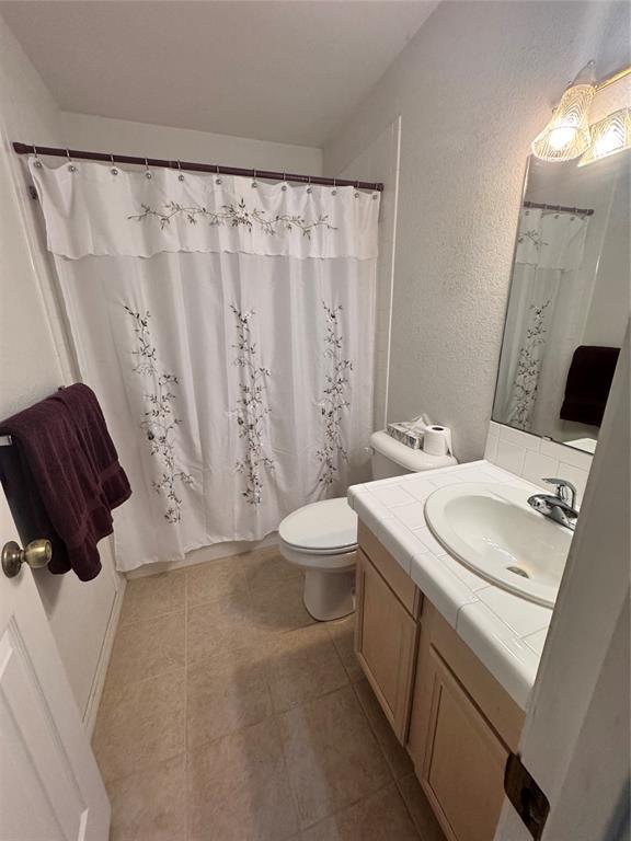 705 Cambridge Dr, Sulphur, OK 73086 - full bathroom with vanity, a textured wall, toilet, and tile patterned flooring