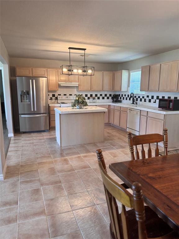 705 Cambridge Dr, Sulphur, OK 73086 - kitchen with decorative backsplash, a kitchen island, light brown cabinetry, under cabinet range hood, and white appliances