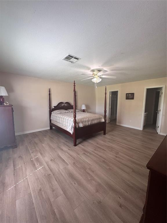 705 Cambridge Dr, Sulphur, OK 73086 - bedroom with baseboards, wood finished floors, and visible vents