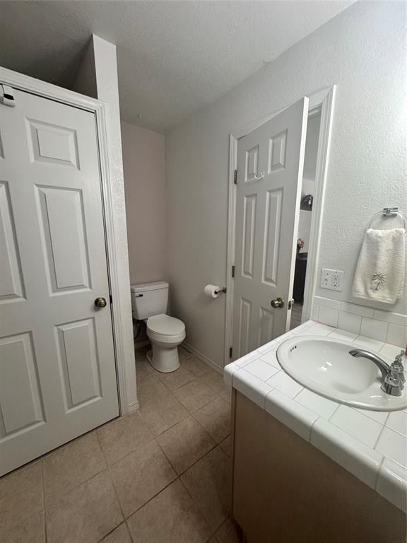 705 Cambridge Dr, Sulphur, OK 73086 - bathroom featuring tile patterned flooring, baseboards, toilet, and vanity