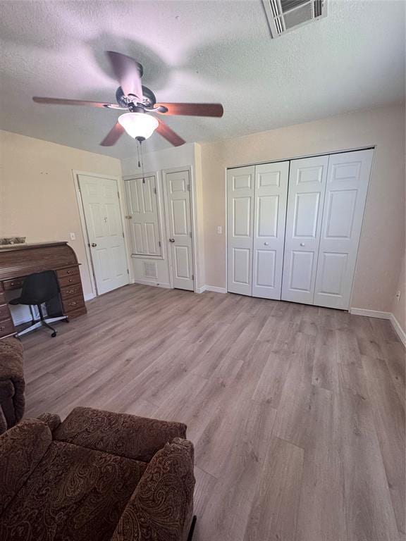 705 Cambridge Dr, Sulphur, OK 73086 - bedroom featuring light wood-style floors, a textured ceiling, a ceiling fan, baseboards, and visible vents