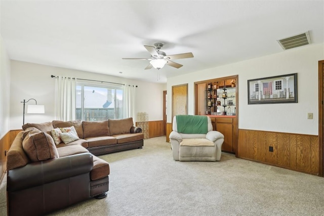10404 Durham Dr, Oklahoma City, OK 73162 - living area with wood walls, carpet, visible vents, and a wainscoted wall