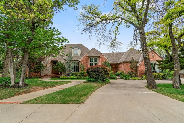 3920 Creek Bank Dr, Edmond, OK 73003 - traditional-style home featuring brick siding, a front lawn, and curved driveway