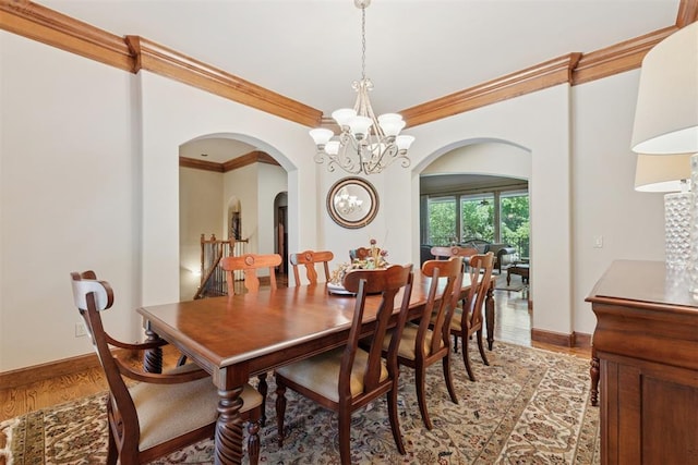 3920 Creek Bank Dr, Edmond, OK 73003 - dining area with arched walkways, a chandelier, ornamental molding, and light wood-style flooring