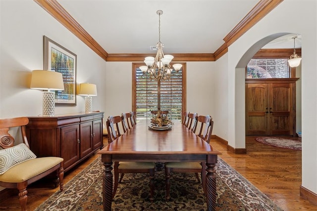 3920 Creek Bank Dr, Edmond, OK 73003 - dining area featuring arched walkways, a chandelier, dark wood-style floors, and crown molding